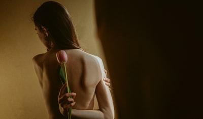 手持绿色塑料玩具的赤裸上身女子